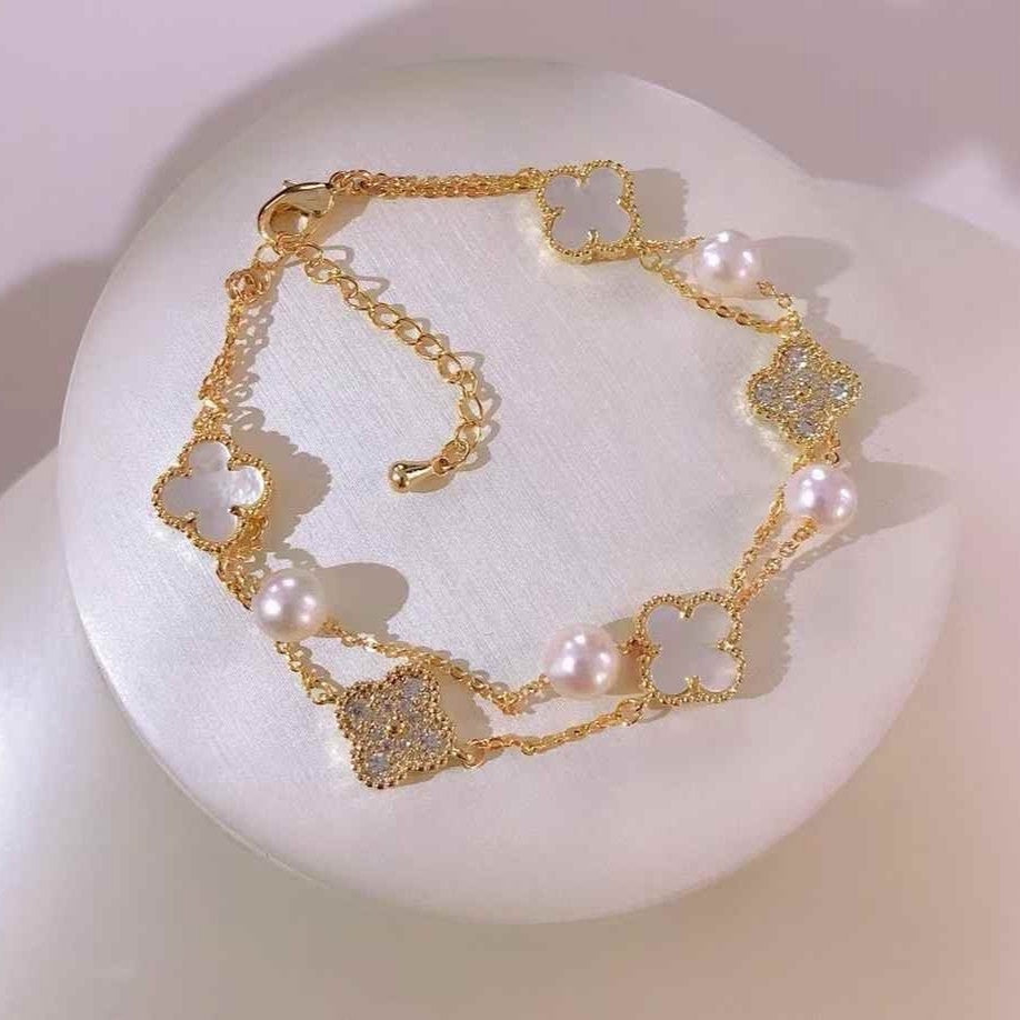 BoxUnboxed gold-plated double-layer bracelet with white pearls and clover charms.
